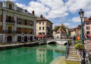 Scenic canal view with historic buildings and bridge in Annecy, France.